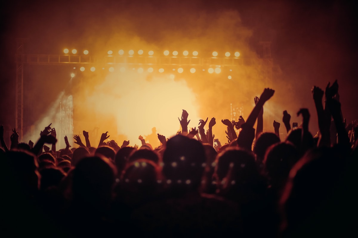 Banda de metal se apresentando ao vivo no palco, sob luzes intensas